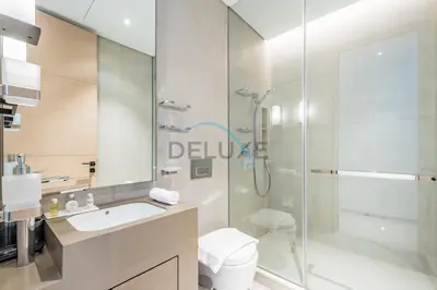 a bathroom with a shower and a toilet and a sink at Grand 3BR Aparment at The Address Residences in JBR by Deluxe Holiday Homes in Dubai