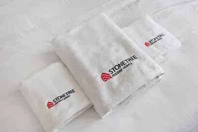 a group of three white towels sitting on a bed at Modern Studio Close To Metro in Dubai