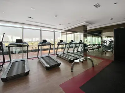 a gym with several tread machines in a building at Modern Studio Close To Metro in Dubai