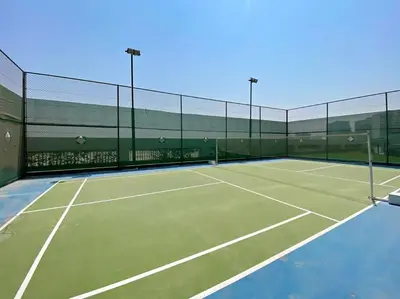 a tennis court with two tennis rackets on it at Modern Studio Close To Metro in Dubai