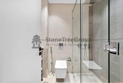 a bathroom with a toilet and a glass shower at Luxury Studio Near To Metro in Dubai