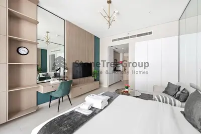 a bedroom with a large white bed and a desk at Luxury Studio Near To Metro in Dubai
