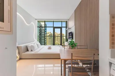 a bedroom with a bed and a table and chairs at Seven Palm Hotel with West beach access in Dubai