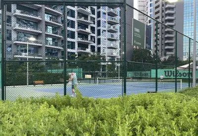 a person is playing tennis on a tennis court at Seven Palm Hotel with West beach access in Dubai