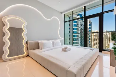 a bedroom with a white bed with a teddy bear on it at Seven Palm Hotel with West beach access in Dubai