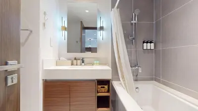 a bathroom with a sink and a tub and a mirror at Creek Edge - Elegant One Bedroom in Creek Habour in Dubai