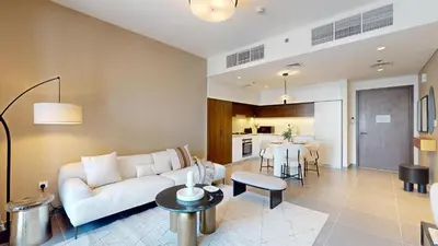 a living room with a white couch and a table at Creek Edge - Elegant One Bedroom in Creek Habour in Dubai