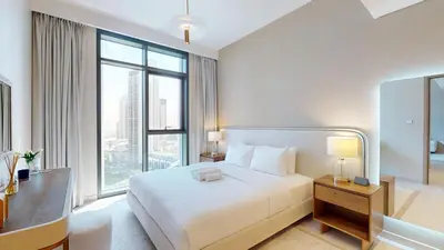 a bedroom with a white bed and a large window at Creek Edge - One Bedroom with Partial Sea View in Dubai