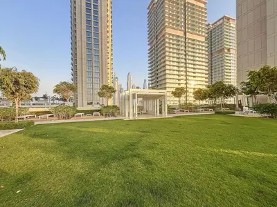 a park in a city with tall buildings at Beach Vista 2 - Two Bedroom with Partial Sea View in Dubai