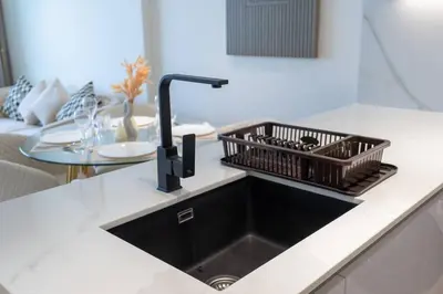a kitchen sink with a dish rack on a counter at Luxurious 1-Bedroom Oasis l Binghatti Corner, JVC in Dubai