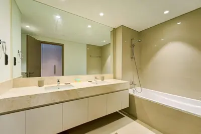a bathroom with two sinks and a mirror and a tub at Stylish 2 Bed with Stunning Burj Khalifa View in Downtown in Dubai