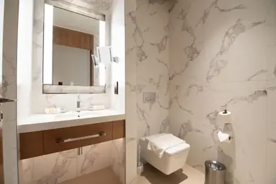 a bathroom with a toilet and a sink and a mirror at Gorgeous High Floor 3-Bed with Full Burj View in Dubai