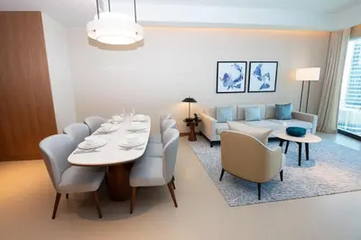 a living room with a table and chairs and a couch at Gorgeous High Floor 3-Bed with Full Burj View in Dubai