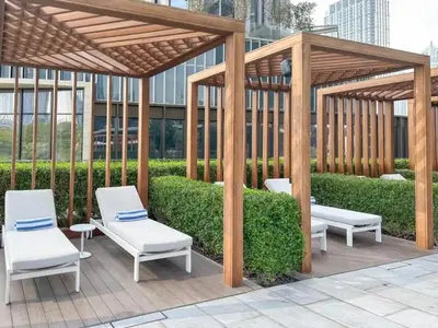 a wooden gazebo with two white chairs under it at Gorgeous High Floor 3-Bed with Full Burj View in Dubai