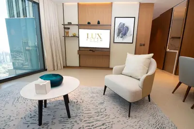 a living room with a chair and a table at Gorgeous High Floor 3-Bed with Full Burj View in Dubai