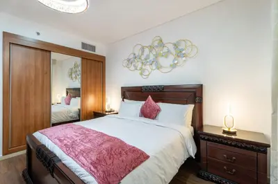 a bedroom with a large bed and a chandelier at Veer Apartments - 87th Floor Penthouse Full Sea View 5 BHK in Dubai