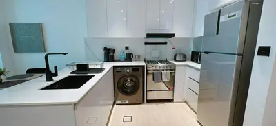 a kitchen with a washer and a sink and a refrigerator at Stylish 1br Apt Jvc W Pool & Free Parking in Dubai
