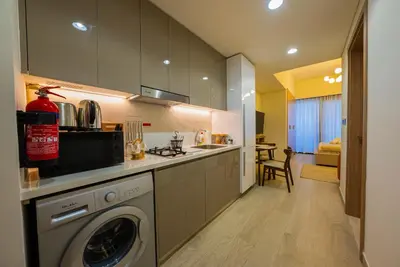 a kitchen with a washer and dryer in a room at Elegant Studio with Pool Access & Private Terrace in Dubai