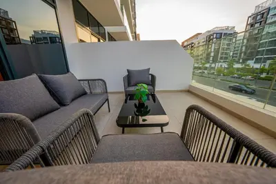 a balcony with two couches and a table with a plant at Elegant Studio with Pool Access & Private Terrace in Dubai