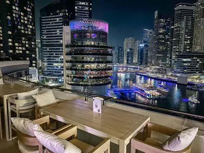 a restaurant with a view of a city at night at Splendid Cozy Studio - Address Dubai Marina in Dubai