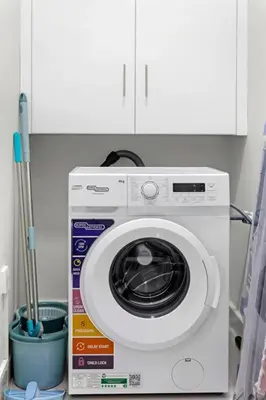 a white washing machine sitting in a kitchen at 4BR Jumeirah Beach Stay with Dubai Eye Views & Near Marina Walk in Dubai