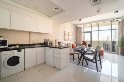 a kitchen with a washing machine and a dining room at Frank Porter - DAMAC Tower 108 - 1BR in Dubai