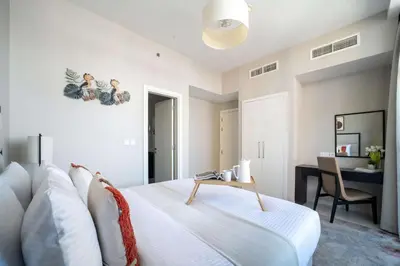 a bedroom with a white bed and a desk at Frank Porter - DAMAC Tower 108 - 1BR in Dubai