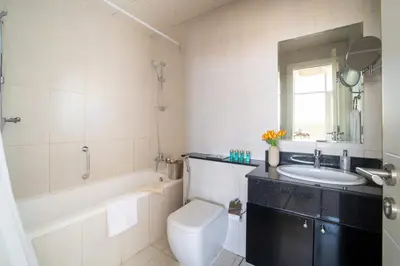 a bathroom with a sink and a toilet and a mirror at Frank Porter - DAMAC Tower 108 - 1BR in Dubai