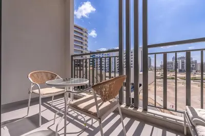a balcony with a table and chairs and a view of the ocean at TOP Location and Work and Chill near Miracle Garden in Dubai