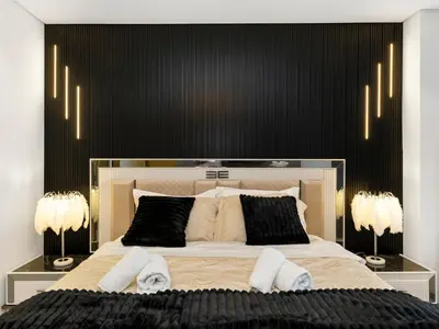 a bedroom with a large bed with a black headboard at Stunning 2BR with Burj View & Infinity Pool in Dubai