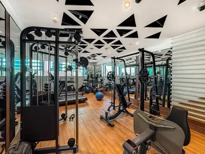 a gym with treadmills and elliptical machines at Lovely Studio with Pool and Gym in Dubai