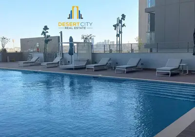 a swimming pool with lounge chairs next to a building at Fully Furnished 2 Bed in Sobha Creek Vista Reserve, Hosted by Desert City Stays in Dubai