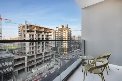 a balcony with two chairs and a view of a city at Daniels 1BR at Jumeirah Garden City in Dubai