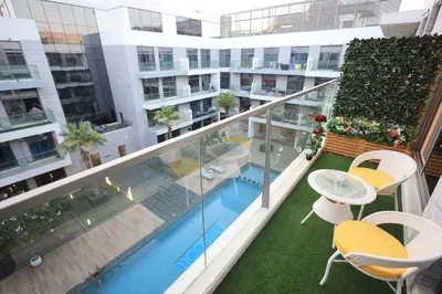 an apartment balcony with a swimming pool and chairs at VIP Experience Dubai Nad Al Sheba at Prime Views- Opposite Al Meydan Hotel- Modern Luxury Apartment in Dubai