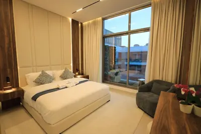 a bedroom with a bed and a couch and a window at VIP Experience Dubai Nad Al Sheba at Prime Views- Opposite Al Meydan Hotel- Modern Luxury Apartment in Dubai