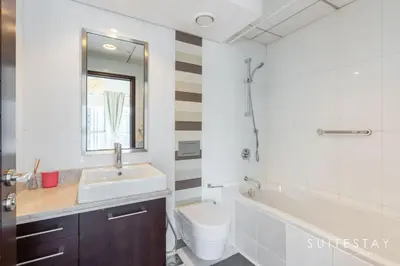 a bathroom with a sink and a tub and a toilet at One Bed with Burj Khalifa View in Dubai