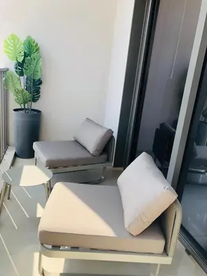 a room with two beds and a table and a plant at MAG 960 Stylish Luxury Apartment 6 Minutes to Burj Khalifa with Complimentary Guest Welcome Pack in Dubai