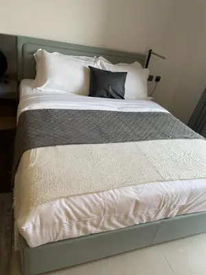 a bed with a gray frame and white pillows at MAG 960 Stylish Luxury Apartment 6 Minutes to Burj Khalifa with Complimentary Guest Welcome Pack in Dubai
