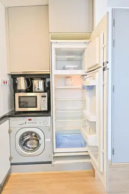a kitchen with an open refrigerator and a microwave at Upgraded Luxury Studio Apartment - Marina View - 5-Star Hotel Amenities in Dubai