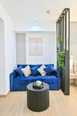 a blue couch in a living room with a table at Upgraded Luxury Studio Apartment - Marina View - 5-Star Hotel Amenities in Dubai