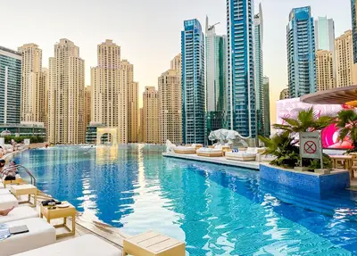 a large swimming pool in a city with tall buildings at Upgraded Luxury Studio Apartment - Marina View - 5-Star Hotel Amenities in Dubai