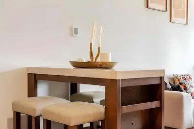 a dining room table with stools and a bowl on top at 804 Yansoon 5 Amazing 1BR Apt Downtown Dubai in Dubai
