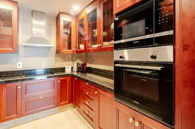 a kitchen with wooden cabinets and black appliances at 804 Yansoon 5 Amazing 1BR Apt Downtown Dubai in Dubai