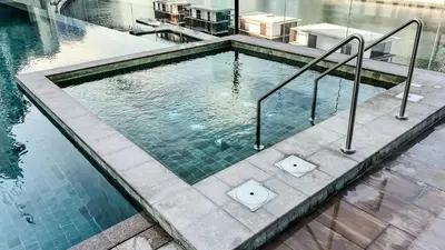 a swimming pool with metal rails in a building at Chic 1-Bedroom with Epic Burj Khalifa Views in Dubai