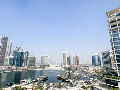 a view of a city with boats in a harbor at Chic 1-Bedroom with Epic Burj Khalifa Views in Dubai