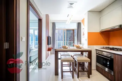 a kitchen with an island with stools and a counter top at 1BR With Burj Khalifa View and Accomodates 4 People in Dubai