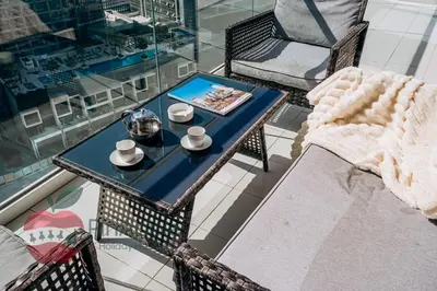 a table and chairs on a balcony with a coffee table at 1BR With Burj Khalifa View and Accomodates 4 People in Dubai
