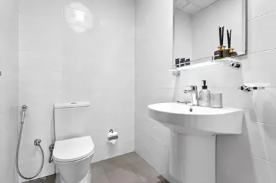 a white bathroom with a sink and a toilet at Premium 1 bedroom Apartment near Dubai Mall in Dubai