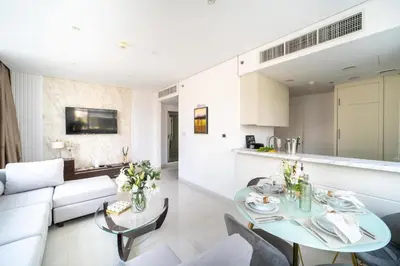 a living room with a table and a couch at Frank Porter - Damac Cour Jardin in Dubai