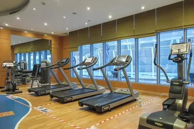 a gym with several treadmills in a row at Frank Porter - Damac Cour Jardin in Dubai